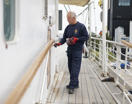 A maintenance team member applying a coat of primer to Britannia. 