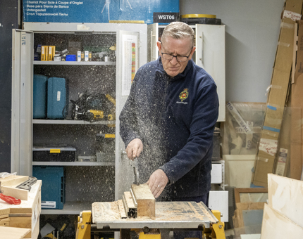 A closer look at the Maintenance team member using the circular saw. 