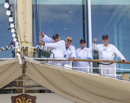 Four Yotties raise a flag outside the Royal Deck Tearoom. 
