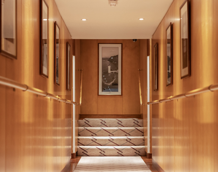 A corridor in Fingal with wooden walls and black and white photographs of lighthouses. 