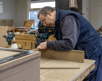 One of the Maintenance team making up wooden drawer units for the new till point. 