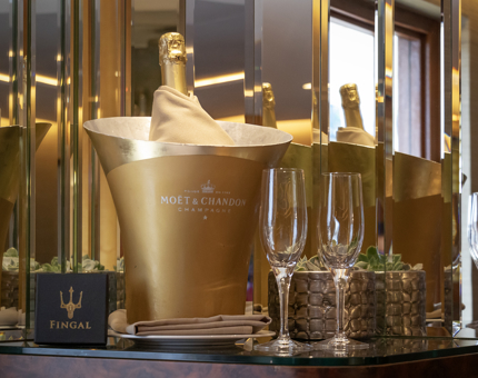 An ice bucket with bottle of Champagne and glasses in a cabin at Fingal. 