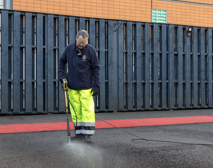 A member of the Facilities team power washing down the compounds outside Britannia. 