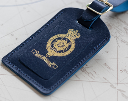 A leather luggage tag embossed with the Britannia crest.