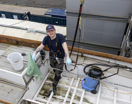A man preparing a whaler for painting. 