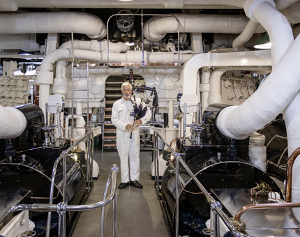 A Yottie playing the bagpipes in Britannia's Engine Room. 