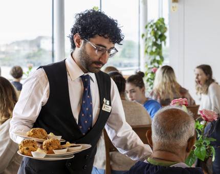 Waiter serving scones in the Royal Deck Tearoom