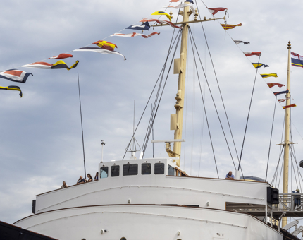 The Bridge of Britannia with multi-coloured dress flags flying high above the mast. 