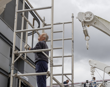 A member of the Maintenance Team fitting the next level of scaffolding. 