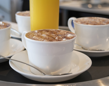 Two kids' hot chocolates in cups and saucers. 