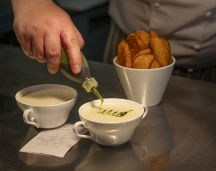 A Chef serving up a bowl of cullen skink soup. 
