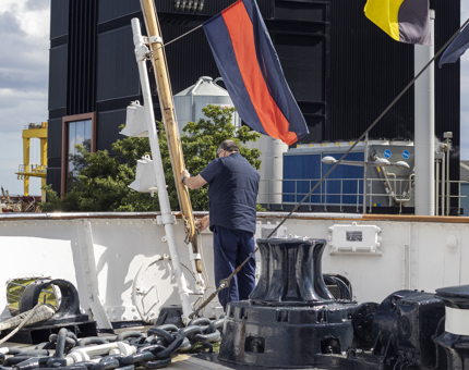 A man is changing a flag. 