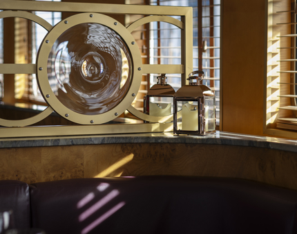 Detail of a seating area next to the windows in the Lighthouse Restaurant & Bar aboard Fingal. 