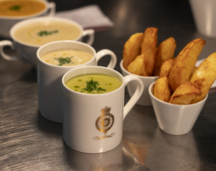 In the Galley, mugs of soup and bowls of potato wedges waiting to be served. 
