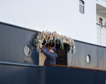 A man putting up the Christmas lights at Fingal's entrance.