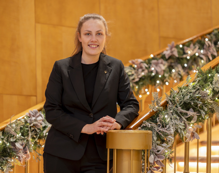 A member of the Hospitality team poses for a photo on the Ballroom's staircase. 