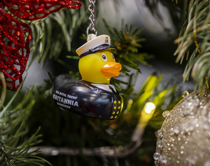 An Admiral duck key chain hanging on a Christmas tree. 