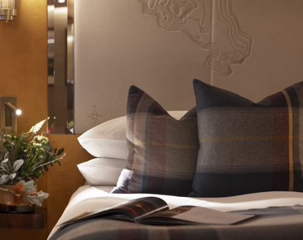 A close-up of a bed with tartan pillow cases. 