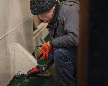 A maintenance team member painting the floor of the stabilizer compartment. 
