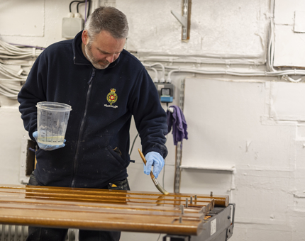 A man varnishing handrails. 