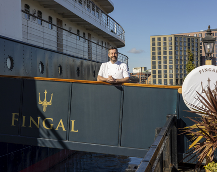 A chef is on the gangway leading to Fingal Hotel's entrance in Leith. 