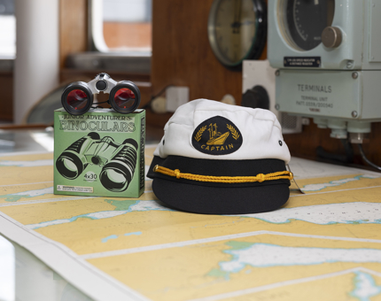 A children's Captain's hat and binoculars, item sold in the Shop.  