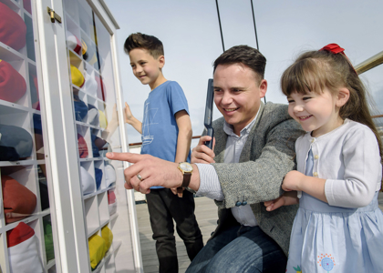 Father, son and daughter on the Flag Deck with audio handset. 