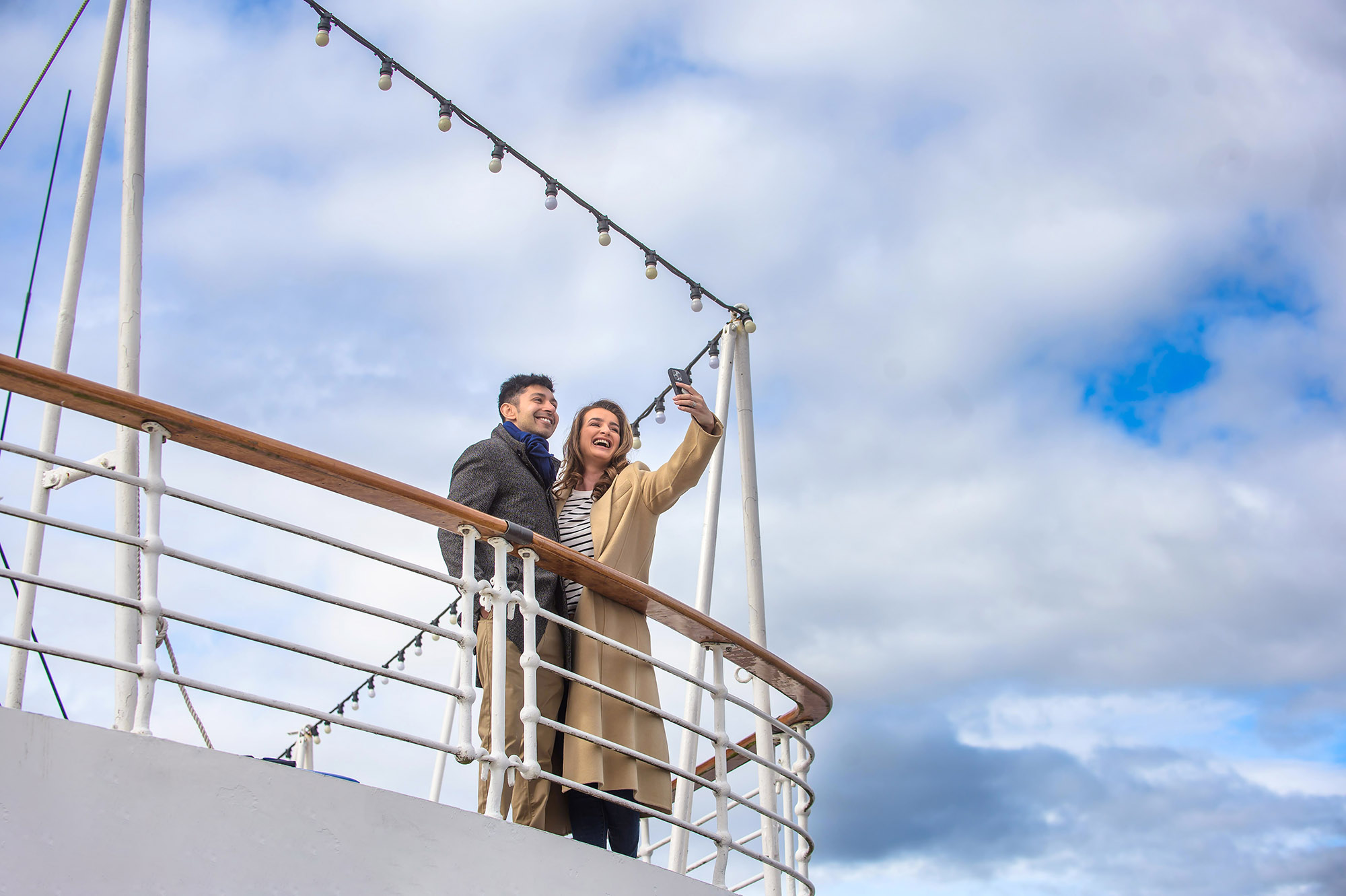 Couple taking a picture from a deck of a ship