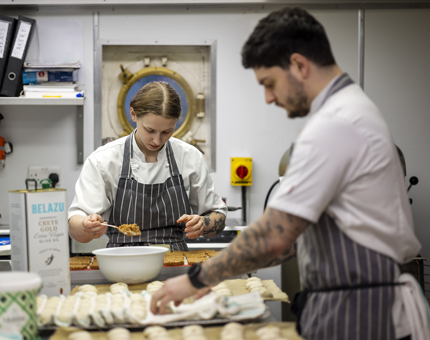 Amelia, Chef de Partie, making cheesecake bases & Bob, Junior Sous Chef making  rolls