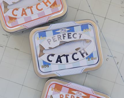 Perfect Catch tine featuring a fish illustration. It has milk chocolate inside. 