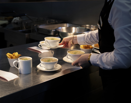 A server from the Tearoom collecting soups from the Galley pass. 