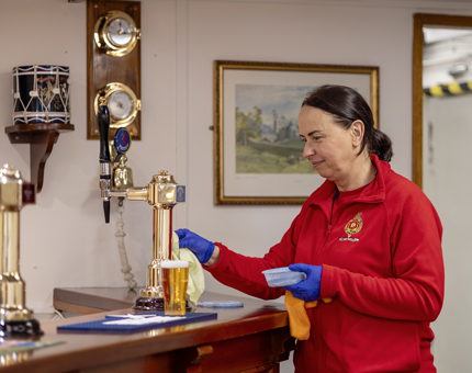 Housekeeper, Renata cleaning brass in CPO's Mess