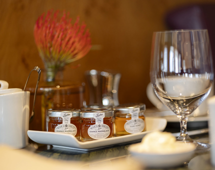 A close-up of a table set in Fingal's Lighthouse Restaurant in Leith. There is a tray of marmalades and jams, glasses and a sugar pot. 