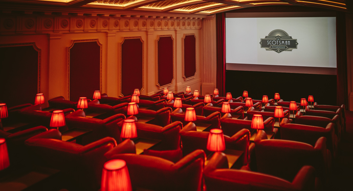 Inside the old fashioned-style Scotsman Picturehouse with rows of plush red velvet seats and small red lamps next to each seat. 