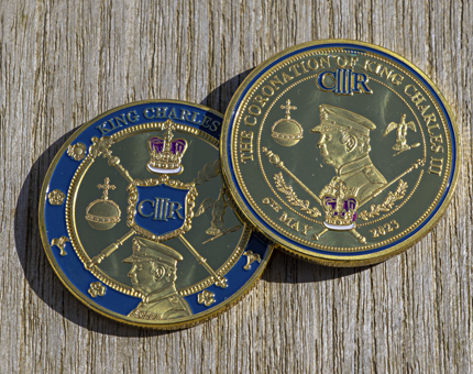 Two souvenir gold coloured coins to celebrate the Coronation of King Charles III.