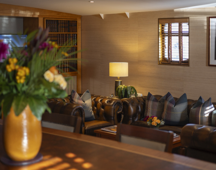 A view of Fingal Hotel's Skerryvore Suites living room. There is large brown leather chesterfield sofas. 