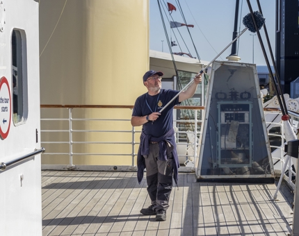 A man with a long duster ensuring that Britannia's Bridge is cleaned. 