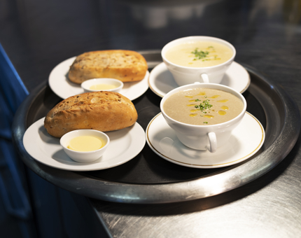 A tray with 2 bowls of soup and 2 bread rolls in the Royal Deck Tearoom's Galley. 