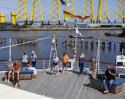 Vistors soaking up the sun on Britannia's Verandah Deck in the Port of Leith. 
