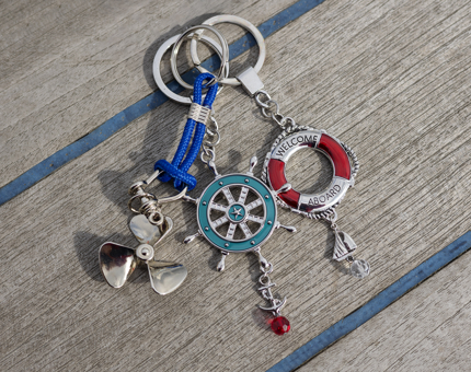 Three nautical keyrings, there is a ship's propeller, ship's wheel and life bouy. 