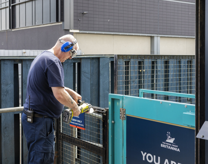 A man is mending a metal gate at Britannia in Leith. 
