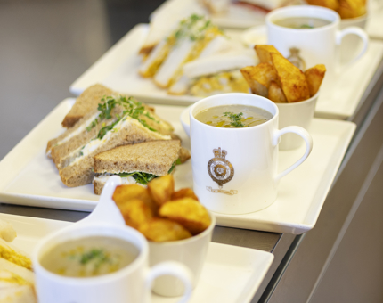 Plates with sandwiches, potato wedges and mugs of soup are lined up on the Galley's bench, ready to be served in the Tearoom. 