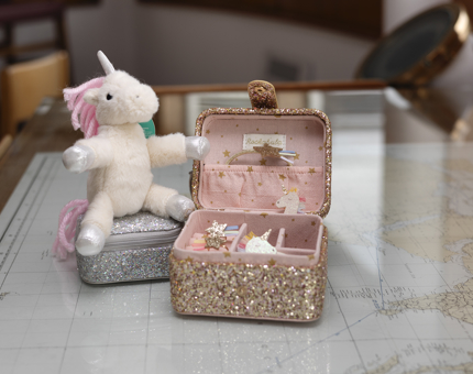 Two kids jewellery boxes and a unicorn plush toy. 