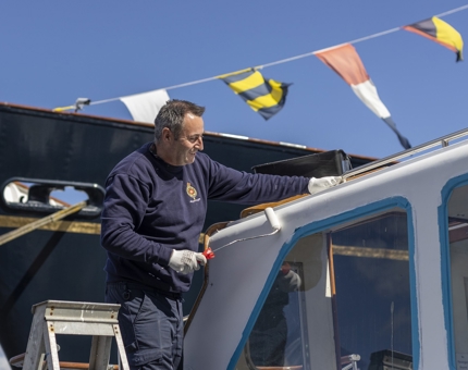 Chris painting the top of the activity boat