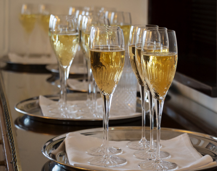 Glasses of Champagne on silver trays ready to be served at an evening event aboard Britannia. 