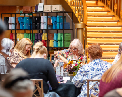 Guests in Fingal's Ballroom sitting at tables making bags for the Islander bags and Harris Gin event. 