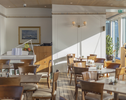 The Royal Deck Tearoom in Leith. The sun is streaming in the windows onto the tables and white grand piano. 