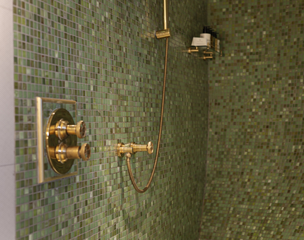 A look at the shower details in Fingal's cabins, there are small green tiles and brass fittings. 