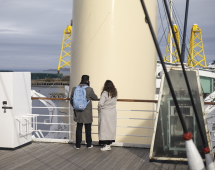 Two people looking at the ship's funnel on The Royal Yacht Britannia. 