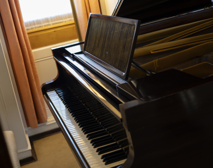 A close up of the Welmar baby grand piano which is located in the Drawing Room. 